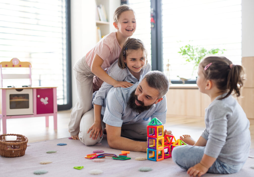 father relaxing and playing with daughters instead of laundry